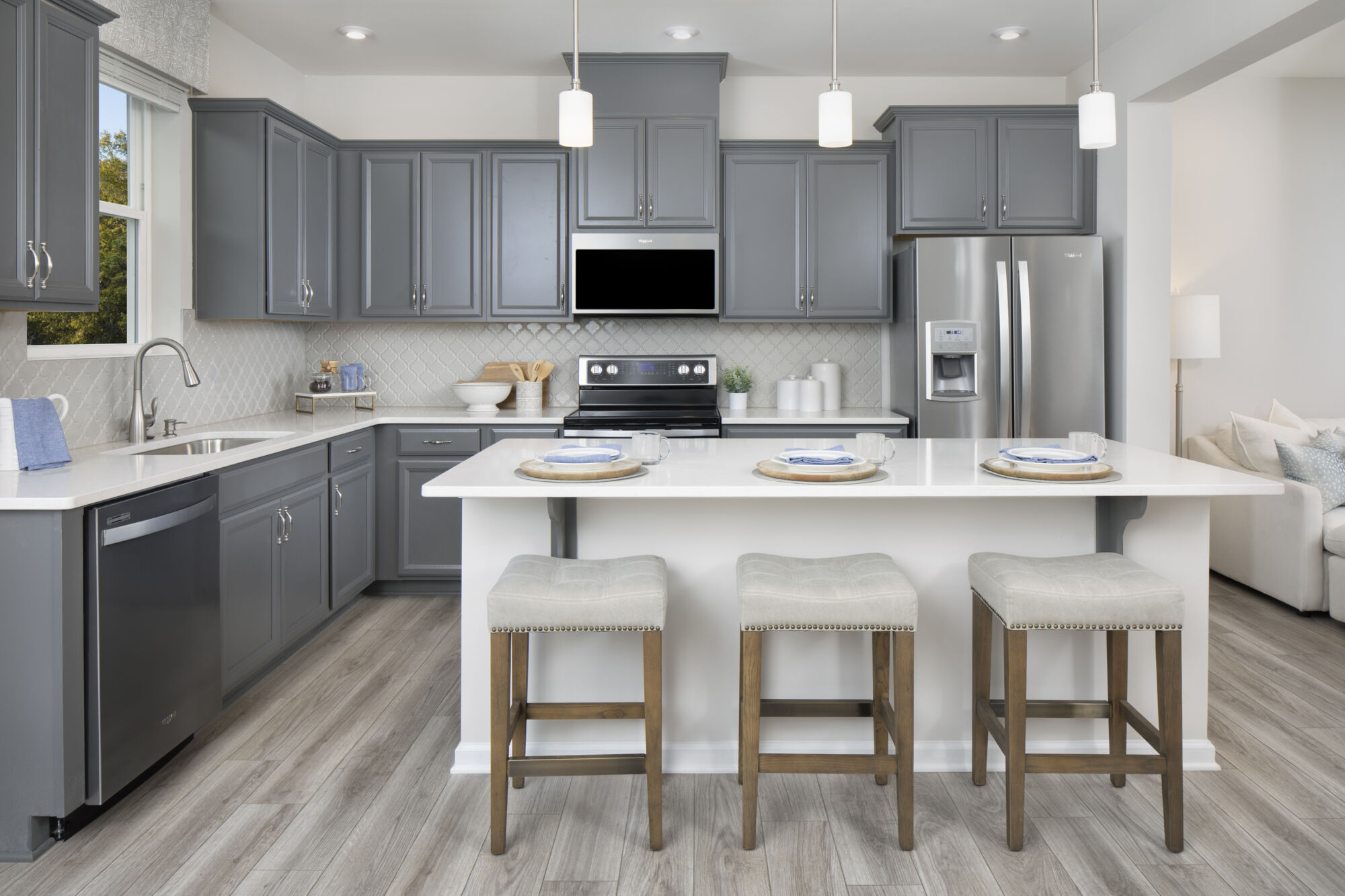 U-Shaped Kitchen with pendant light, window, refrigerator, range and wood flooring